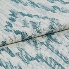 White coloured fabric decorated with patterned stripes of teal across the entire fabric