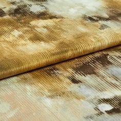A folded piece of fabric decorated with aurora ember in dusty gold, brown and white 