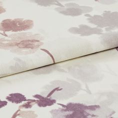 folded fabric with a repeating floral pattern in purple, pink and grey