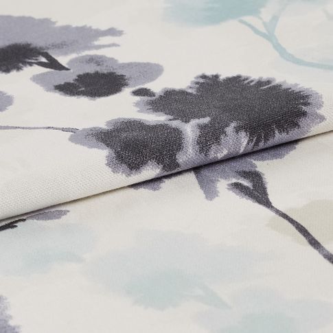 White fabric that is decorated with flowers in an ink blot style 
