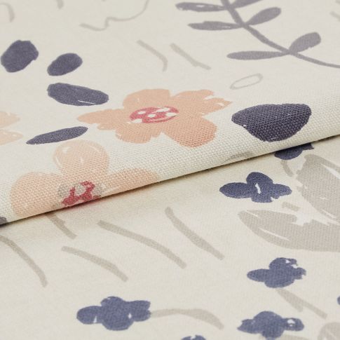Cream coloured fabric with flowers in a variety of shapes and colours that pattern the material