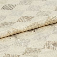 Repeating geometric diamond patterns are decorated in neutral tones of grey and beige against cream coloured fabric