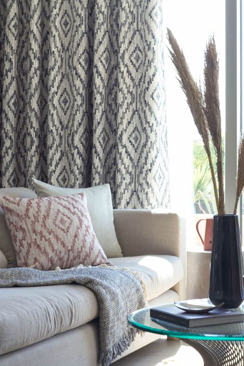 Close up detail of sofa with geometric print curtains 