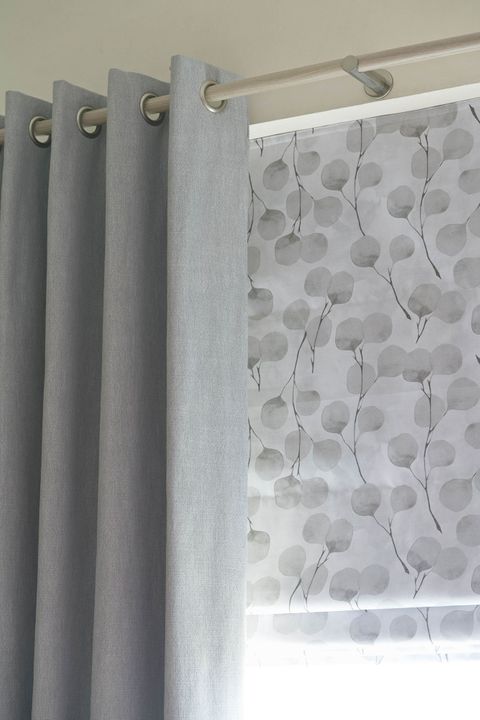 Close up of Bailey Cloudy curtains and Honesty Frost Roman blinds in bedroom