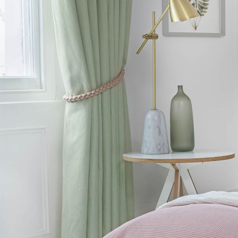 Close up of bailey neo mint curtains with plait tie-back in bedroom