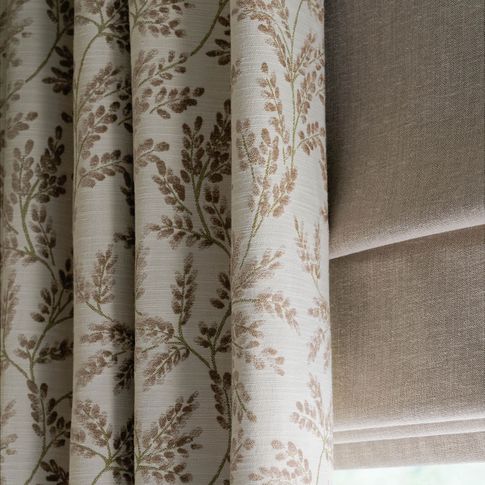 Close up detail of Delizia Taupe curtains and Lindora Linen Roman blinds at a single windowdining room