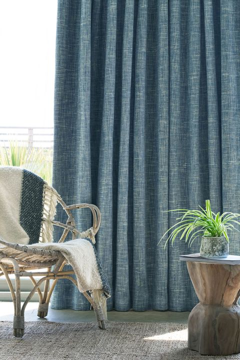 Close up of wicker chair in front of window with Haddie Ocean curtains