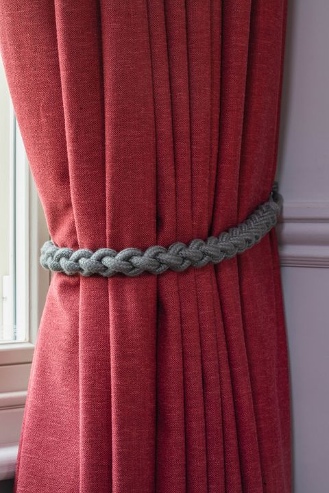 Close up detail of Lindora Ruby curtains with grey rope tie-back