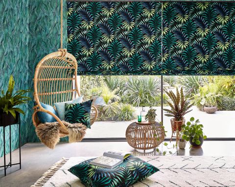 Green and yellow  printed roman blinds on patio, patterned and printed cushions on leisure hanging chair 