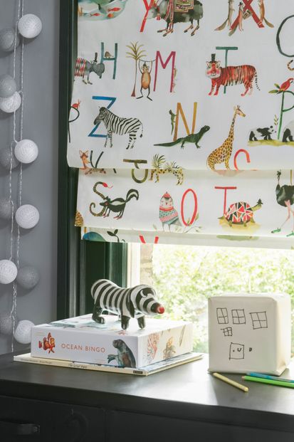 Close up of ABC and animals printed Roman blinds in children's study room