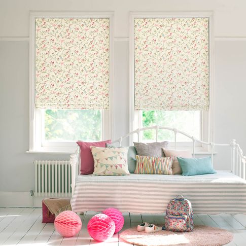 Kids bedroom with summery printed roman blinds and printed cushions on the bed