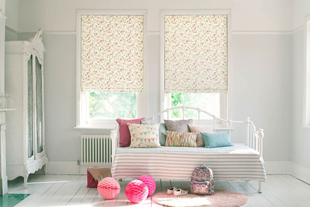 Kids bedroom with summery printed roman blinds and printed cushions on the bed