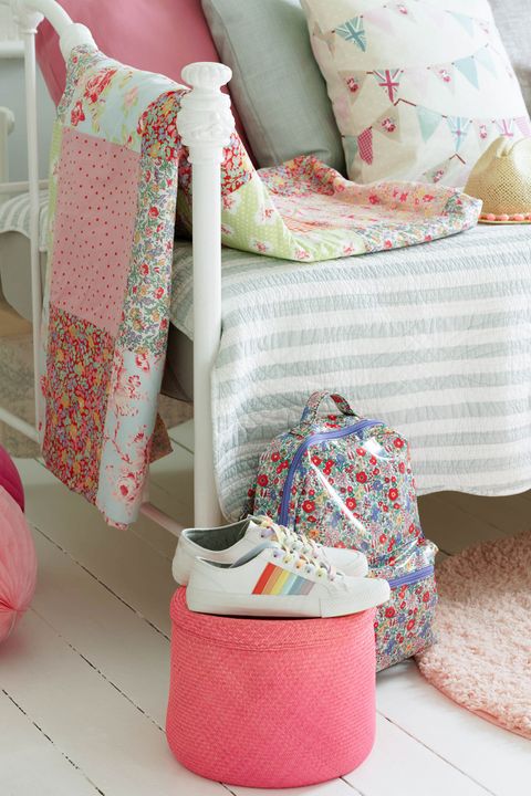 Close up detail of kids bedroom with summery printed cushions on a day bed