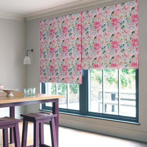 Pink, blue and purple floral roman blinds in a white dining room covering a blue window 