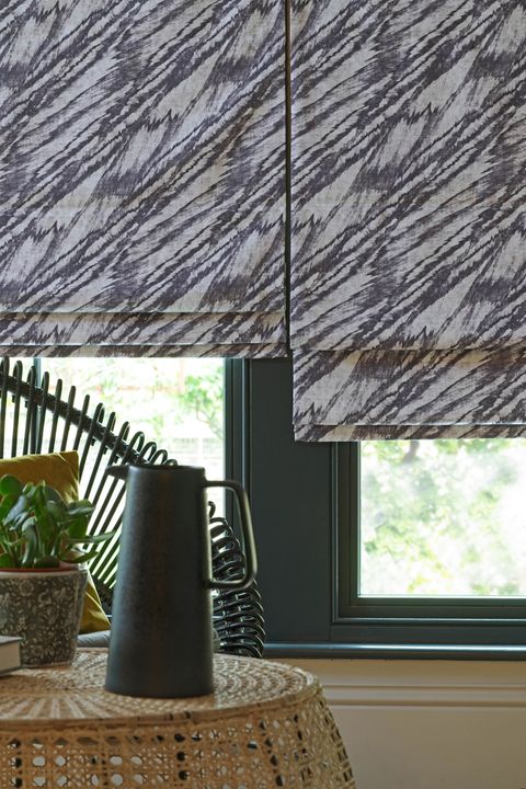 Close up of black and white wave patterned Roman blinds in garden room.