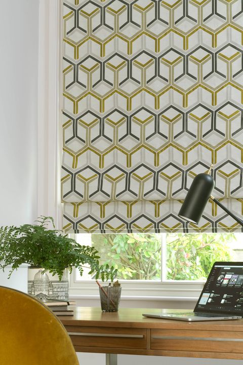 Close up of geometric printed shapes in mustard and grey colors Roman blinds in a home office