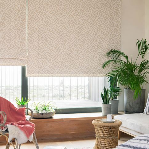 Cream geometric printed roman blinds in a living room 