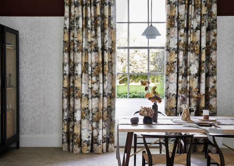 Dining room with floral print velvet curtains