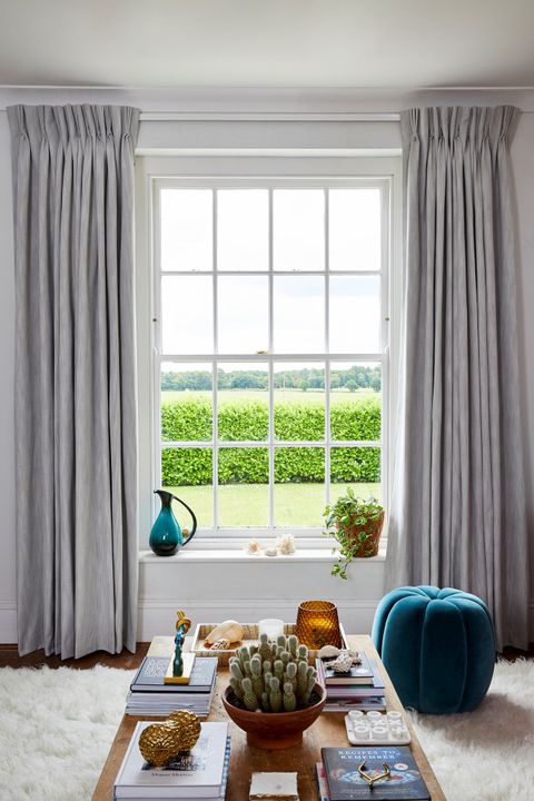 A single sash window dressed with light grey curtains