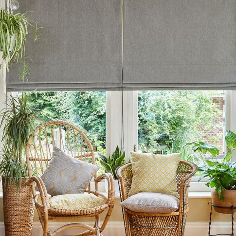 A conservatory with two wicker chairs