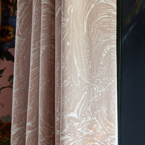 A close up shot of pink curtains featuring a subtle marble print
