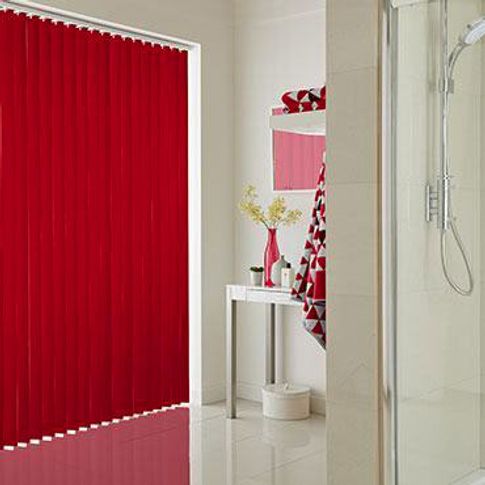 Bright red vertical blinds are fitted to a tall window in a bathroom decorated in red and white