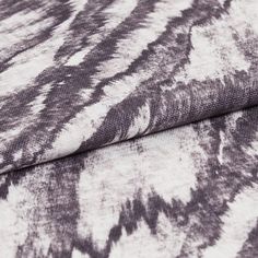 Purple and white patterned drift storm swatch on a ream of fabric