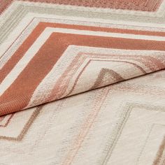 Repeating shades of blush and pink in different thicknesses are patterned on white material 