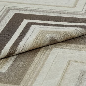 Folded fabric that has a white base colour while the rest of the fabric is patterned with rectangular outlines in brown and beige colours