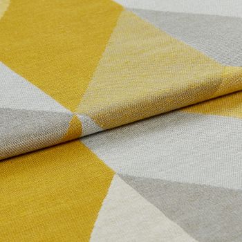 Folded fabric in shades of yellow, grey and white that are arranged in a repeating geometric pattern