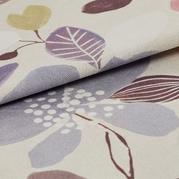 Neutral coloured fabric decorated with flowers and leaves in a variety of colours that repeats throughout the material