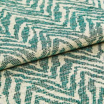 Wave like pattern in teal on folded beige coloured fabric