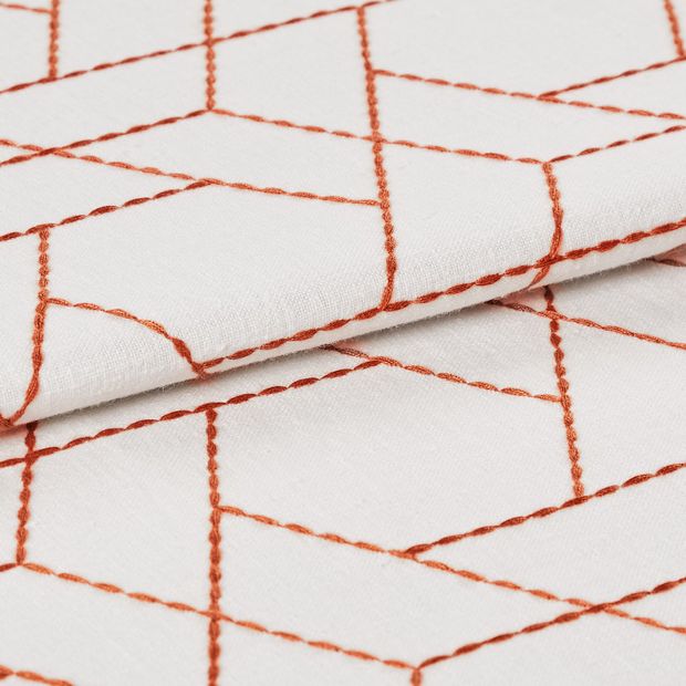 Geometric design outlined in orange on white fabric 