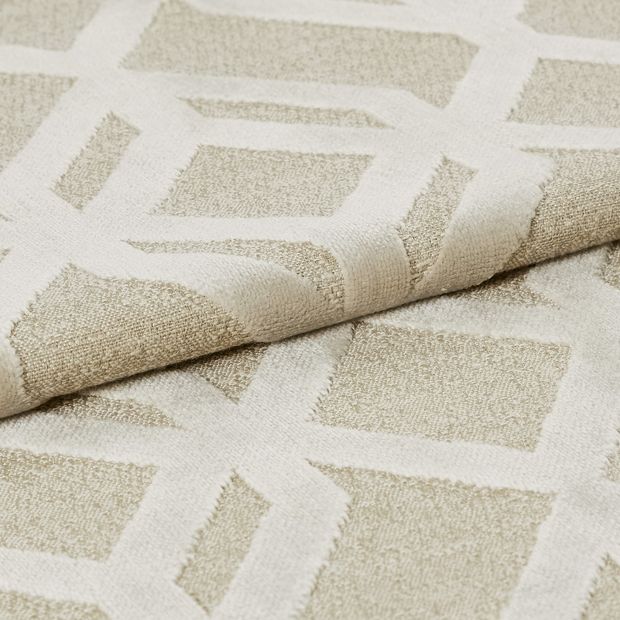 Cream coloured fabric with a repeating geometric pattern in white 