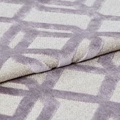 Soft white fabric that has a mauve coloured geometric style which repeats throughout the material