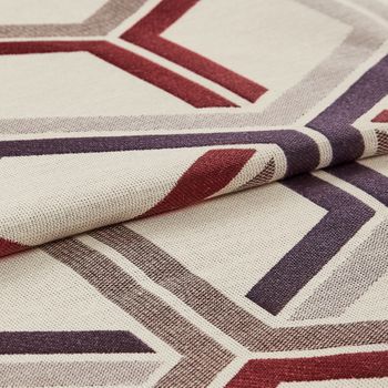 white base coloured fabric that is layered with repeating a geometric design in grey, red and purple