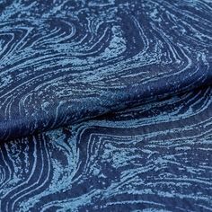 A repeating swirling pattern made up of dark and light blue on the material