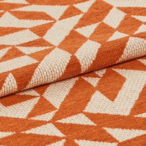 White and orange decorate the fabric in a repeating geometric pattern 