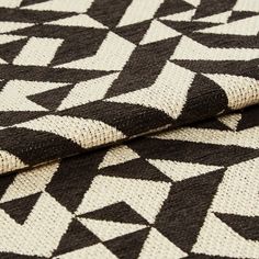 White and black coloured fabric in a repeating geometric pattern across the material