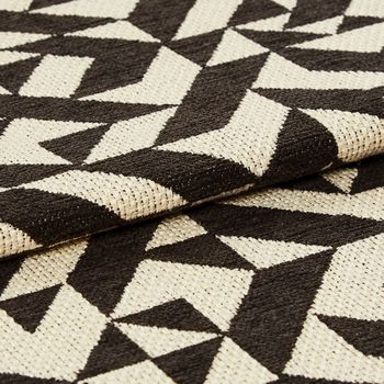 White and black coloured fabric in a repeating geometric pattern across the material
