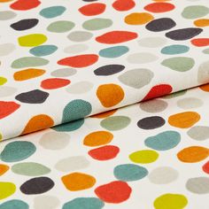 Repeating multi coloured spots on white fabric