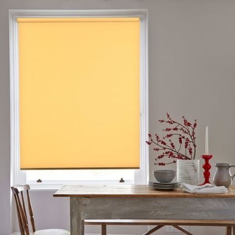 yellow coloured roller blind fitted to a rectangular window in a dining room that has a wooden dining table and chairs