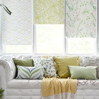 3 different types of Hillarys Floral Blinds in a window behind a sofa 