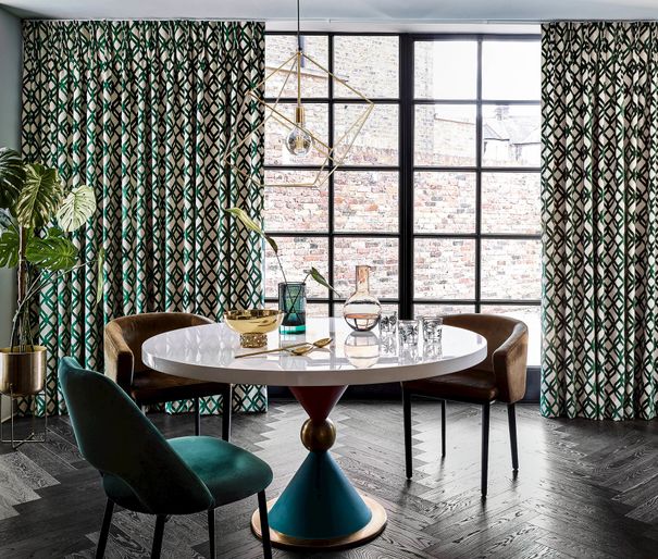 Luxe dining room with crittall doors and green geometric print curtains