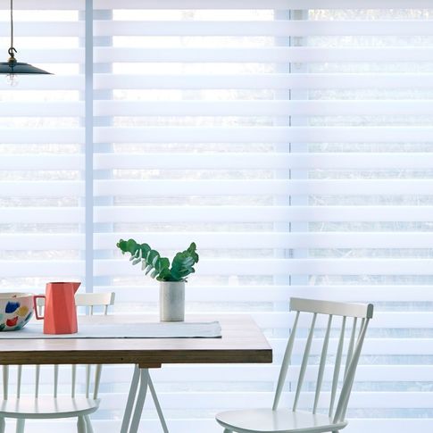 A close up of a white Day & Night blind in a kitchen with a table