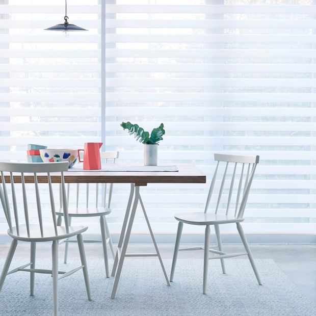 A close up of a white Day & Night blind in a kitchen with a table