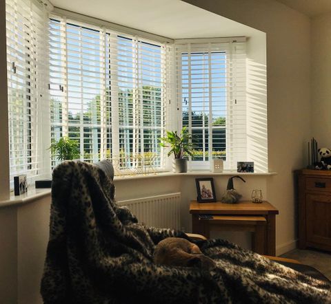 white wooden blinds fitted to a bay window in a living room