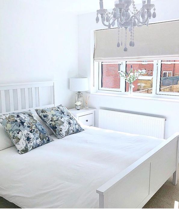 beige roman blinds in white bedroom