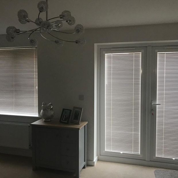 Perfect fit grey venetian blinds on doors and windows in lounge