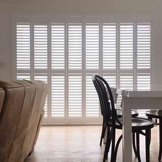 white tracked shutters in dining room